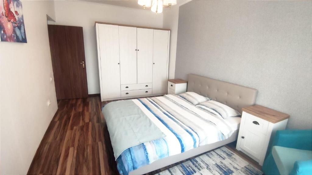 ein Schlafzimmer mit einem Bett und einem großen weißen Schrank in der Unterkunft Charming apartment in villa in Iaşi