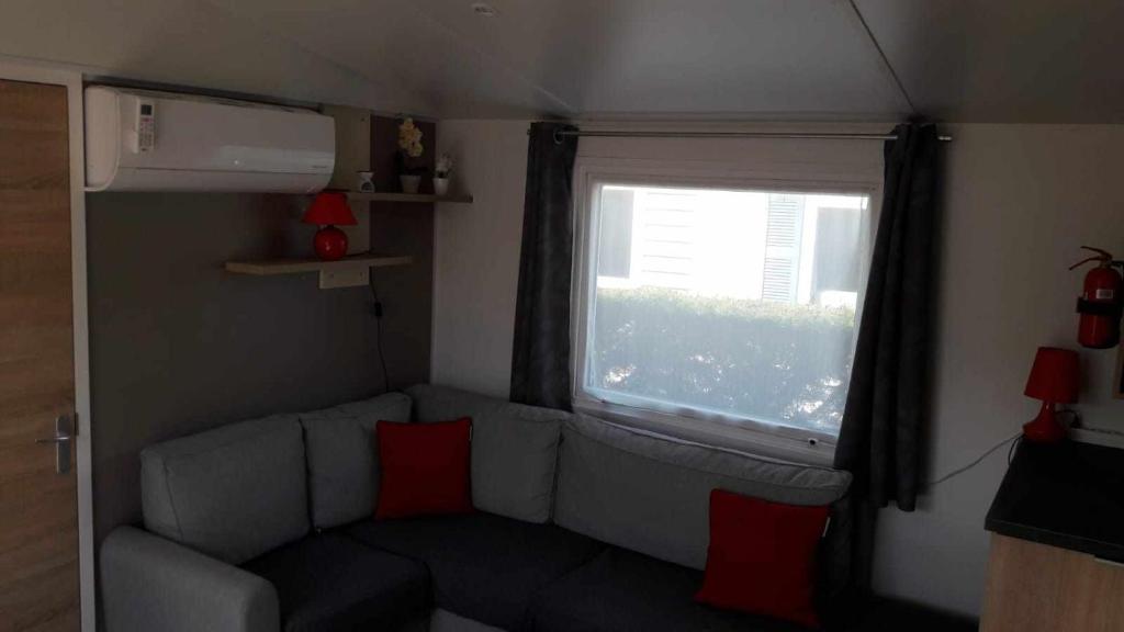 un salon avec un canapé et une fenêtre dans l'établissement 526-Charmettes, aux Mathes