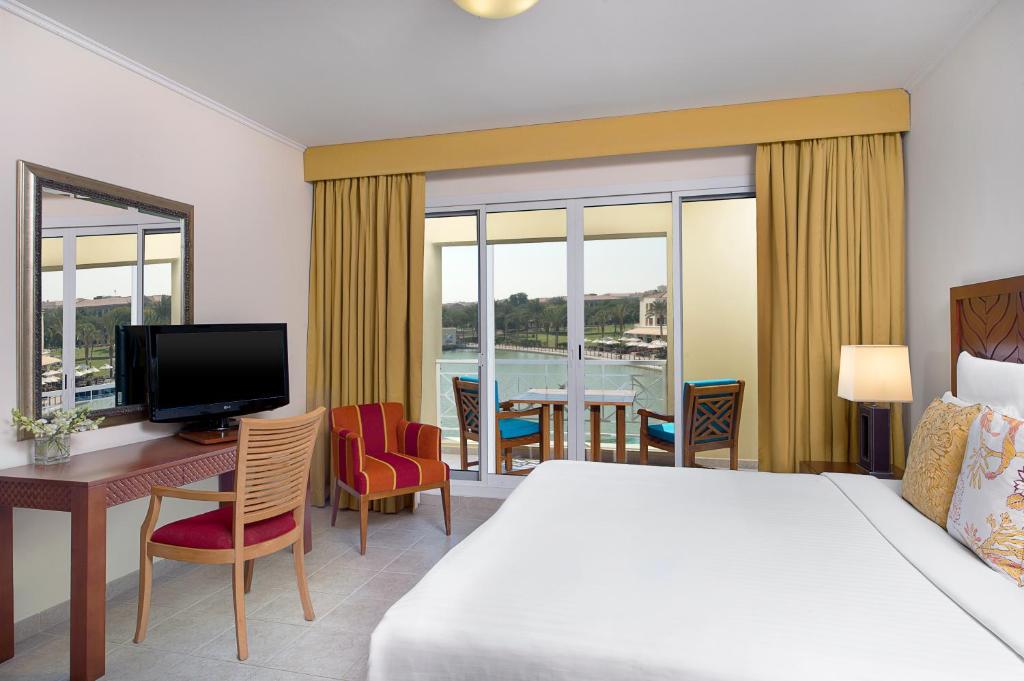 Pokój hotelowy z łóżkiem, biurkiem i telewizorem w obiekcie Copthorne Lakeview Executive Apartments Dubai, Green Community w Dubaju