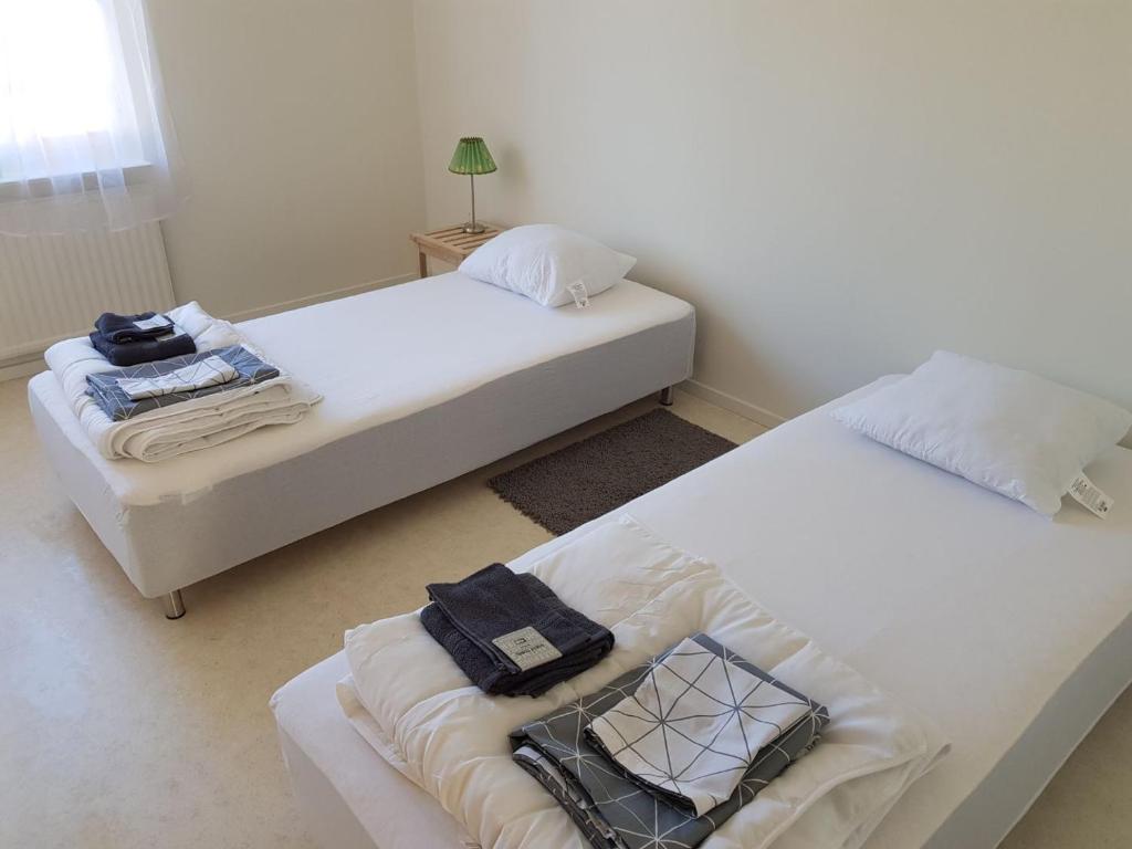 una camera da letto con due letti con asciugamani sopra di Corporate apartment a Fellingsbro