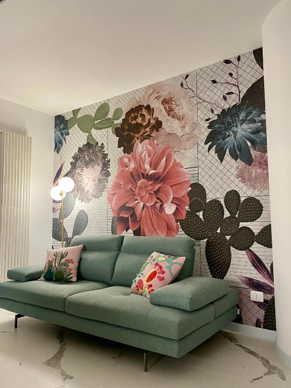 a living room with a green couch in front of a floral wall at Vista mare in Vasto