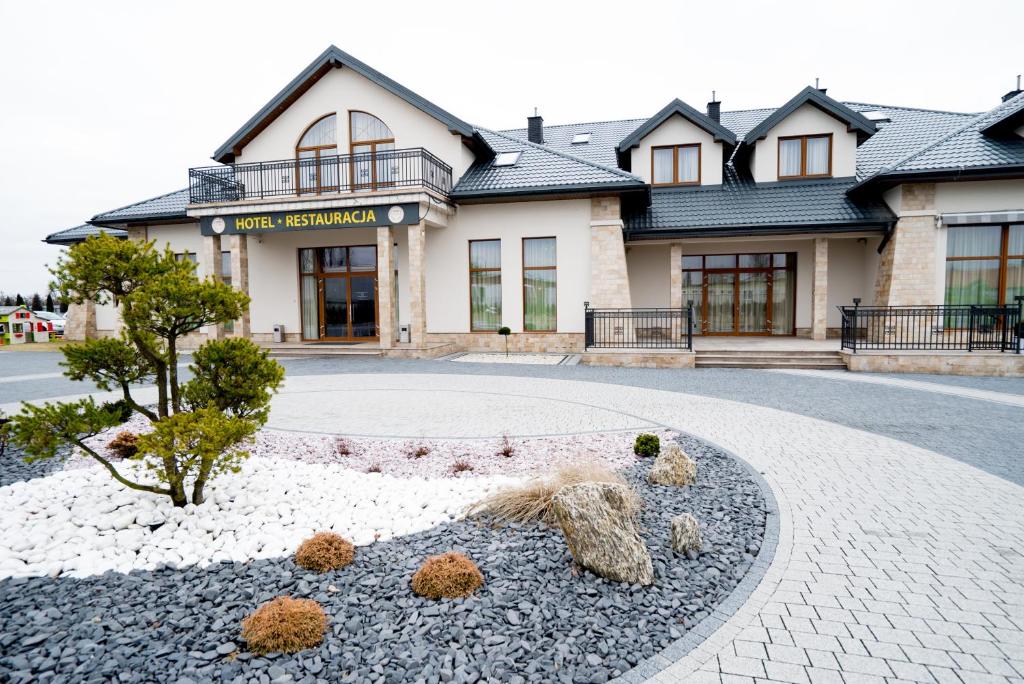 a building with a garden in front of it at Hotel Aleksandria in Siedlce