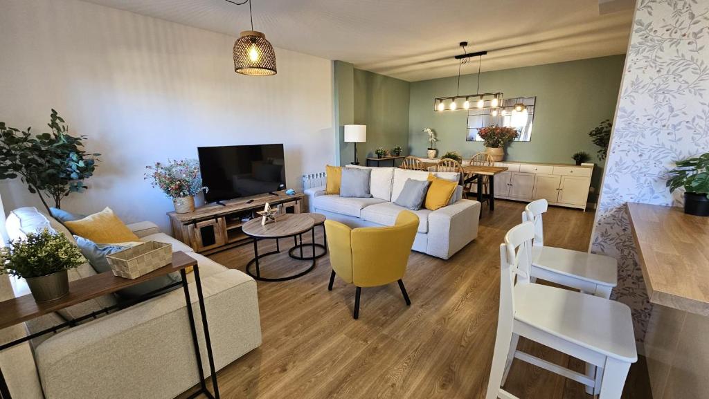 a living room with a white couch and a table at Casa Arenal COMILLAS, grande, céntrico y tranquilo, con jardín y piscina, ideal para familias in Comillas