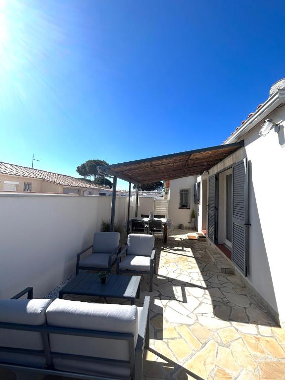 un patio avec des canapés et des chaises sur un toit dans l'établissement Maison tout confort au calme idéal famille 4ESTGNT7, au Barcarès
