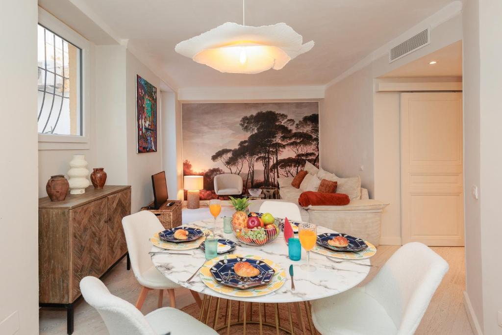 une salle à manger avec une table et des chaises blanches dans l'établissement Perrissol YourHostHelper, à Cannes