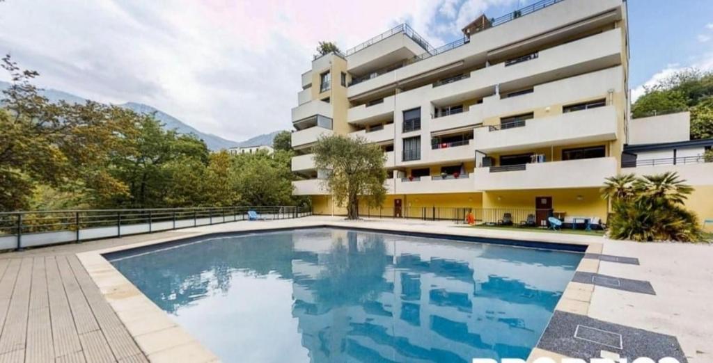 ein Bild eines Swimmingpools vor einem Gebäude in der Unterkunft Jolie appartement avec piscine et parking privé Menton in Gorbio