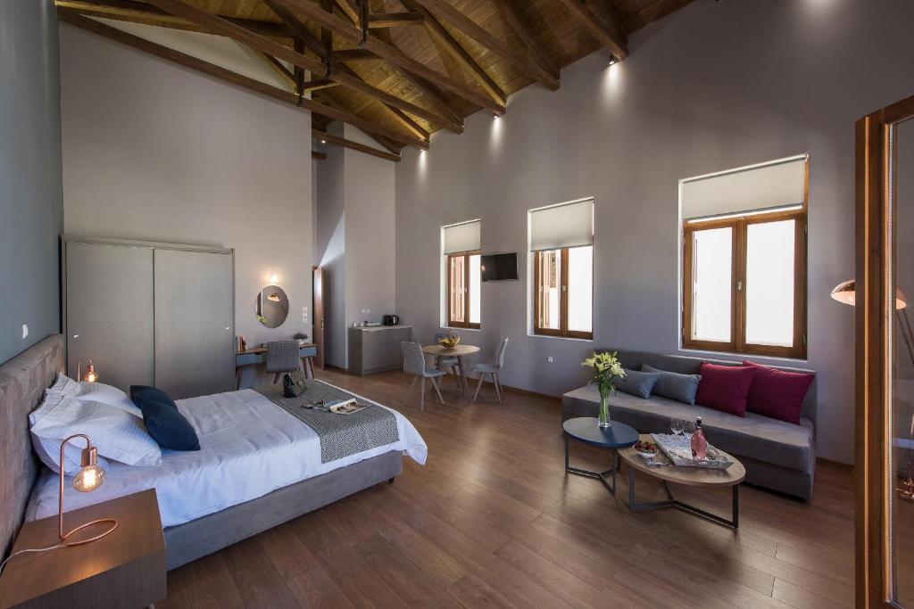 sypialnia z łóżkiem i kanapą w pokoju w obiekcie Bluebell Luxury Suites w Chanii
