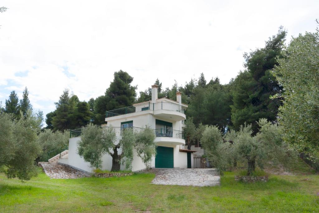 una vecchia casa in mezzo a un campo con alberi di Vetas Vintage Villas - by RentalsPro Akti Elia Halkidiki a Elia