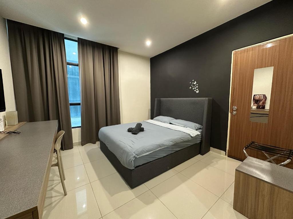 a bedroom with a bed with a teddy bear on it at Cozy Stays Studio C - Kozi Square Kuching in Kuching