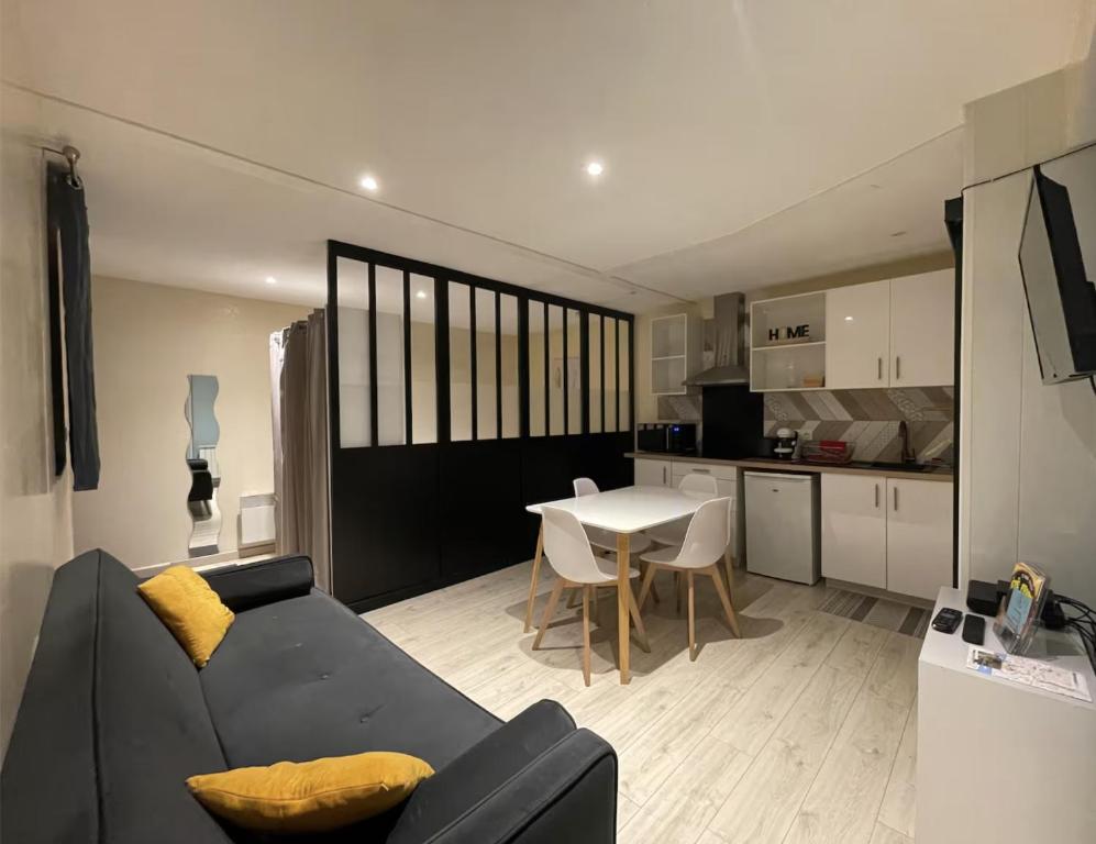 a living room with a black couch and a table at Cabana in Mâcon