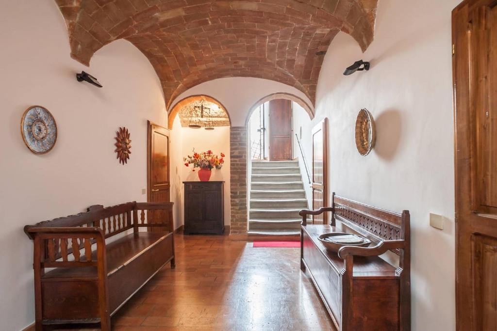 a hallway with two benches and a staircase in a building at Camere Sotto le Stelle in Umbertide