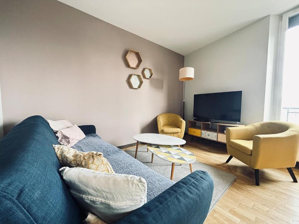 un salon avec un canapé bleu et des chaises dans l'établissement Neufchatel superbe appartement 3 chambres, à Reims
