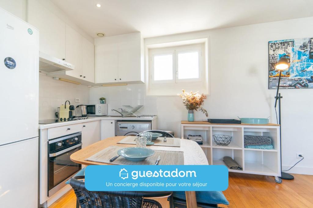 une cuisine avec des armoires blanches et une table en bois dans l'établissement Le Céleste Wifi Sacré-Cœur, à Paris