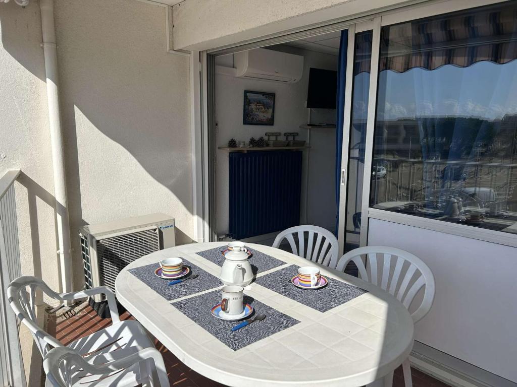 - une table sur un balcon avec 2 tasses de café dans l'établissement Appartement rénové, 4 couchages, proche plage et commerces, parking privé, Port Camargue - FR-1-250-44, au Grau-du-Roi