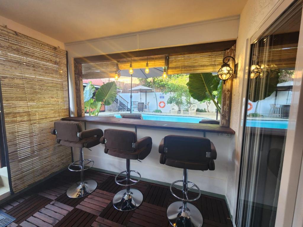 a barber shop with three barber chairs and a swimming pool at The Rustic Vintage Suite in Grand Baie