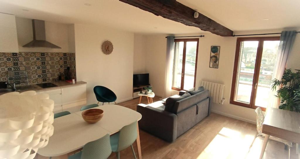 un salon avec un canapé et une table dans l'établissement Paris & Disney - LES BORDS DE MARNE, à Meaux