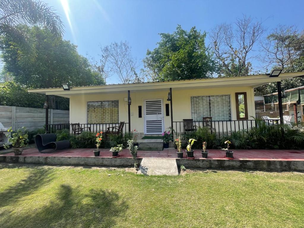 a small yellow house with plants in a yard at Rural Mitra farms in Noida