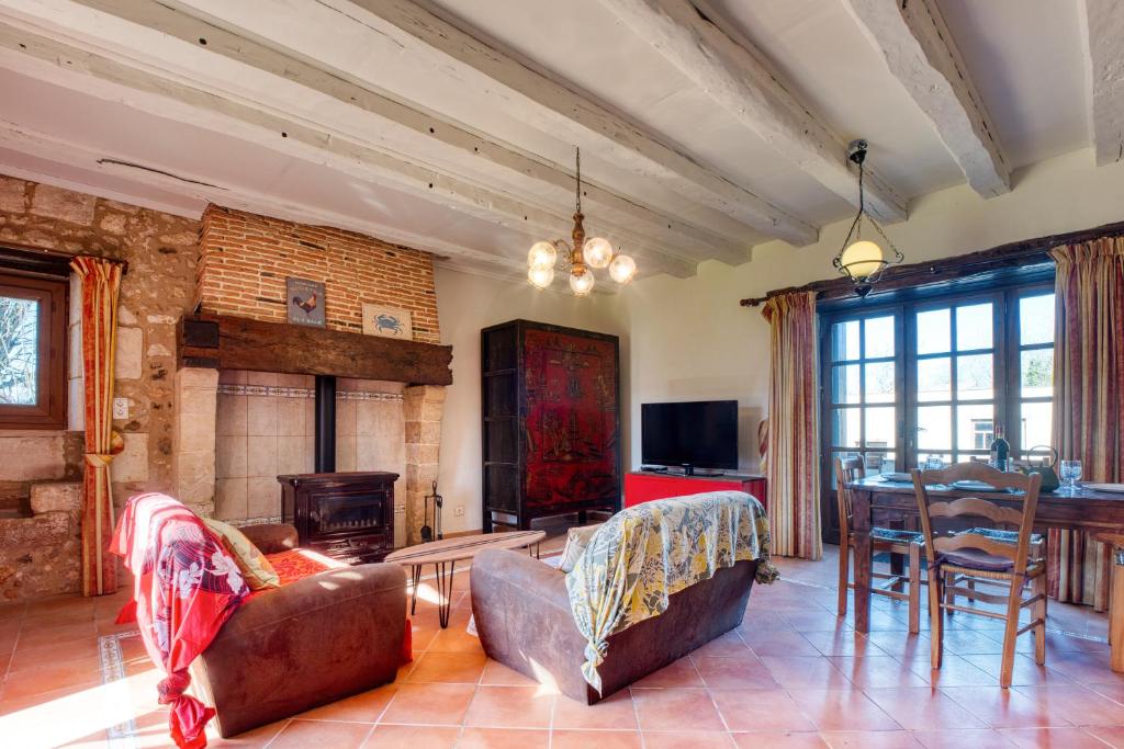 a living room with a couch and a fireplace at Maison Callen in Festalemps