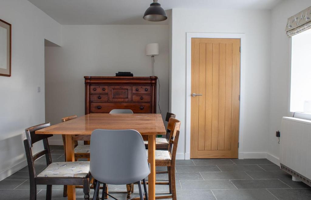 a dining room with a wooden table and chairs at The Old Post Office in Saasaig