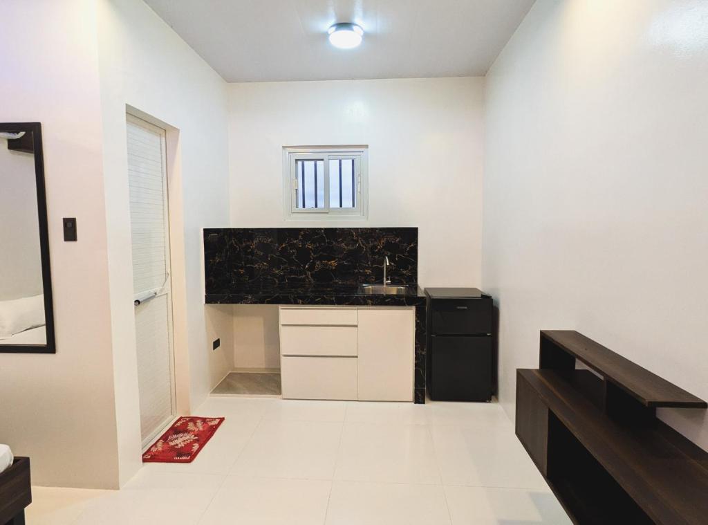 una cucina con pareti bianche e un apparecchio nero di Guestway Transient Inn a Calapan