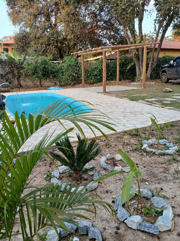 a garden with a swimming pool and a wooden fence at Suítes Serra do Cipó 2 in Santana do Riacho