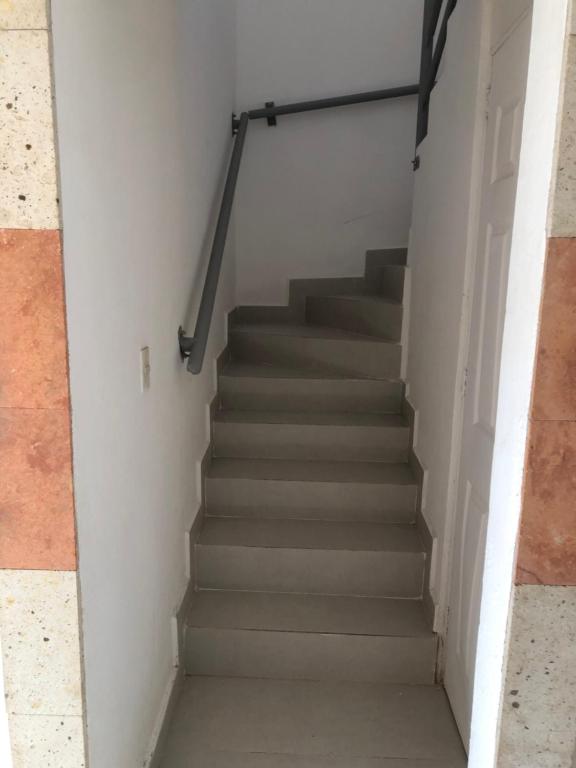 una escalera que conduce a una habitación blanca con escaleras en Villa 305 Acapulco Diamante, en Acapulco