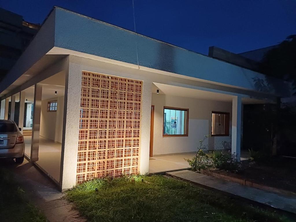 a house with a brick wall in front of it at Casa de praia em Itaúna, Saquarema, Pertinho do mar 150 m da areia com 3 quartos e ar condicionado in Saquarema