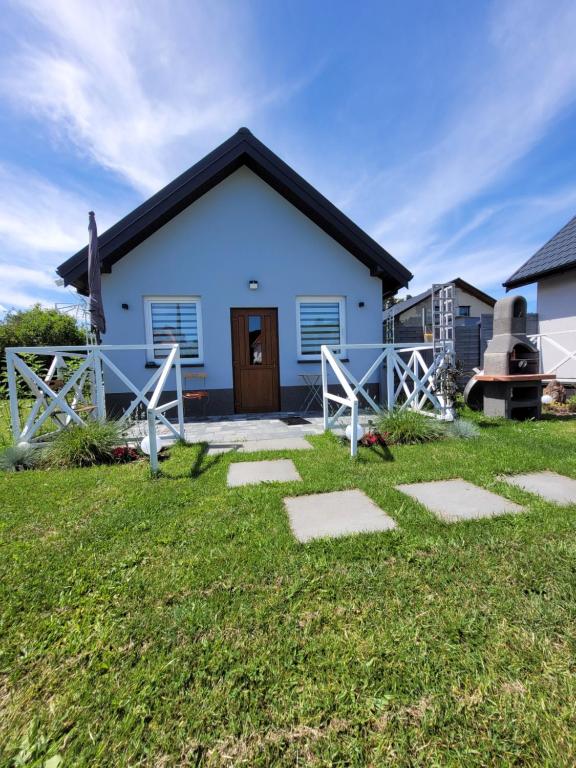a blue house with a pathway in front of it at Domki Eridan, nad morzem in Wisełka