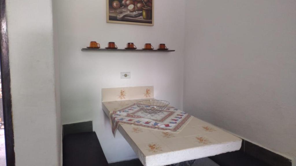 ein kleiner Raum mit einem Tisch und einem Regal in der Unterkunft Seu lar na Praia, Condomínio Vila Gustavo-excelente localização in Caraguatatuba