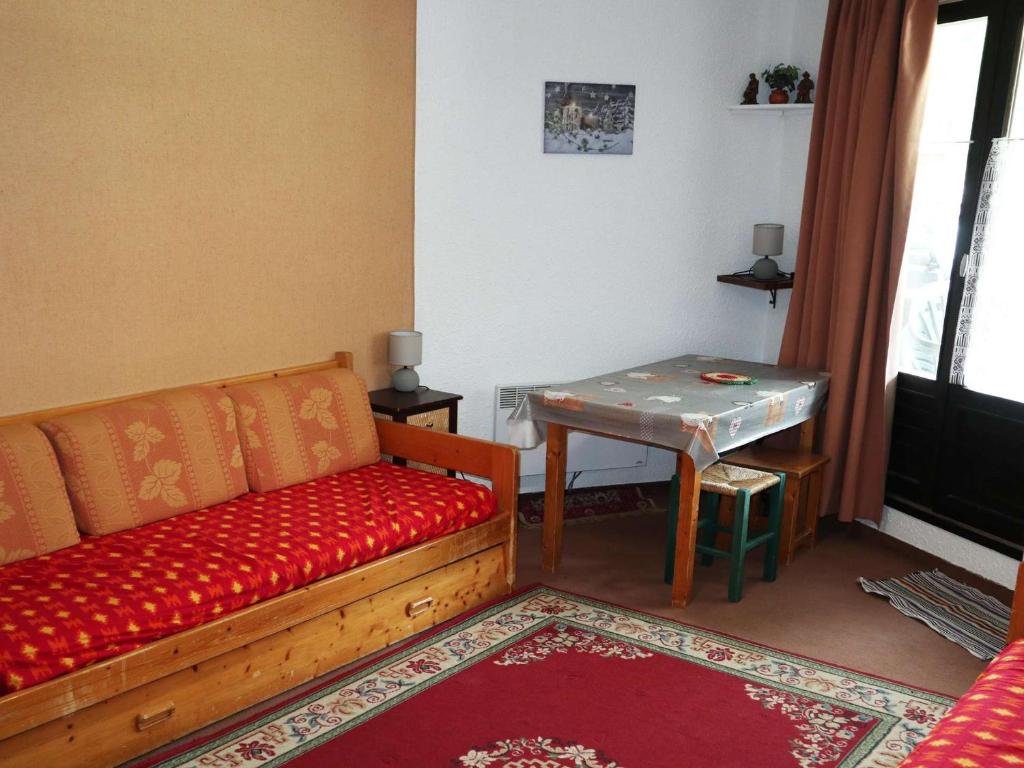un salon avec un canapé rouge et une table dans l'établissement Studio cosy pour 4 pers. au pied des pistes - FR-1-322-292, aux Orres