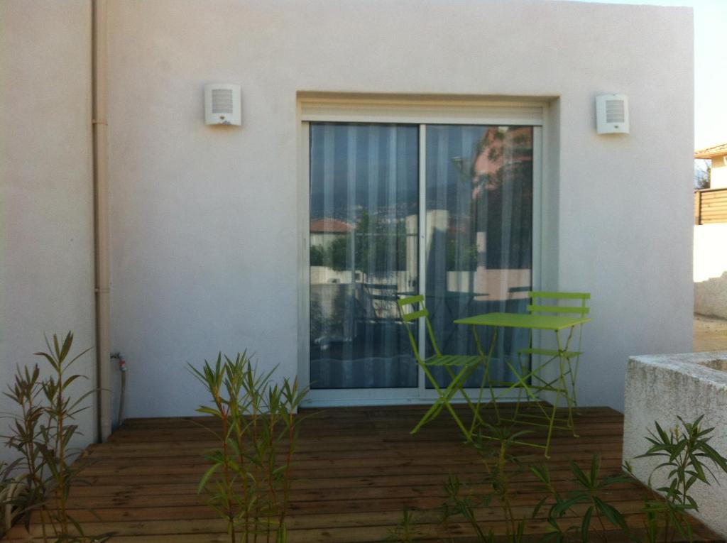 un patio con una mesa verde y una ventana en T2 Campo Meta, en Furiani