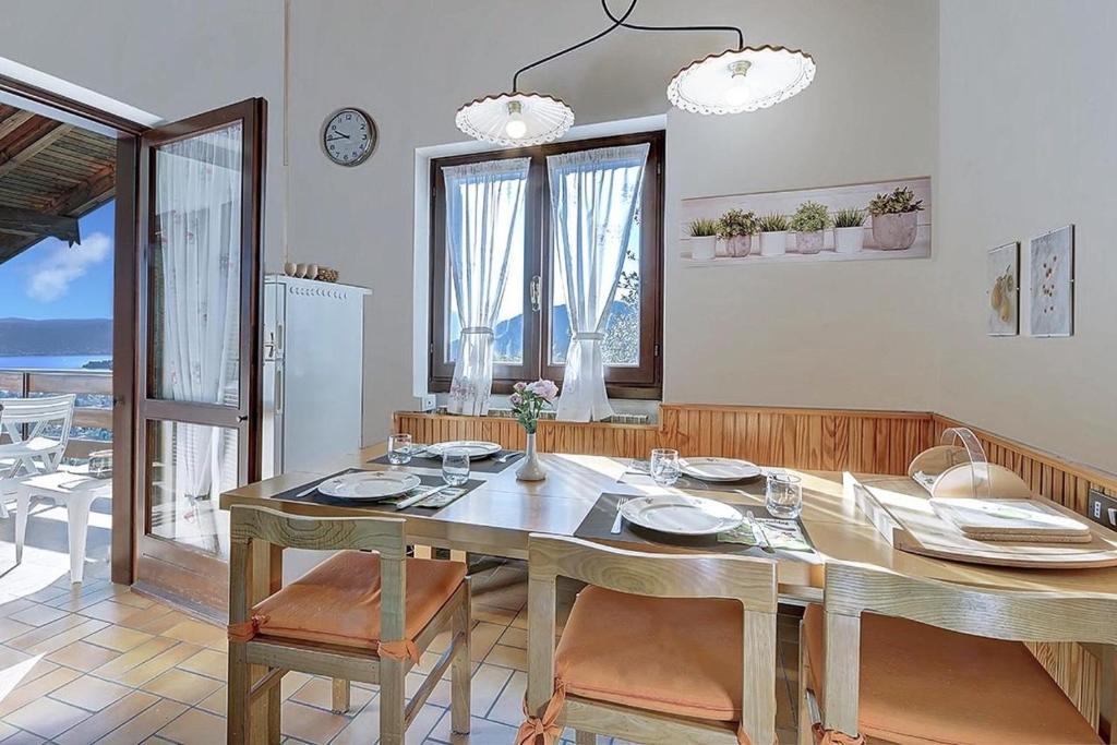 a dining room with a table and chairs with a view of the ocean at Villa Jone in Arizzano