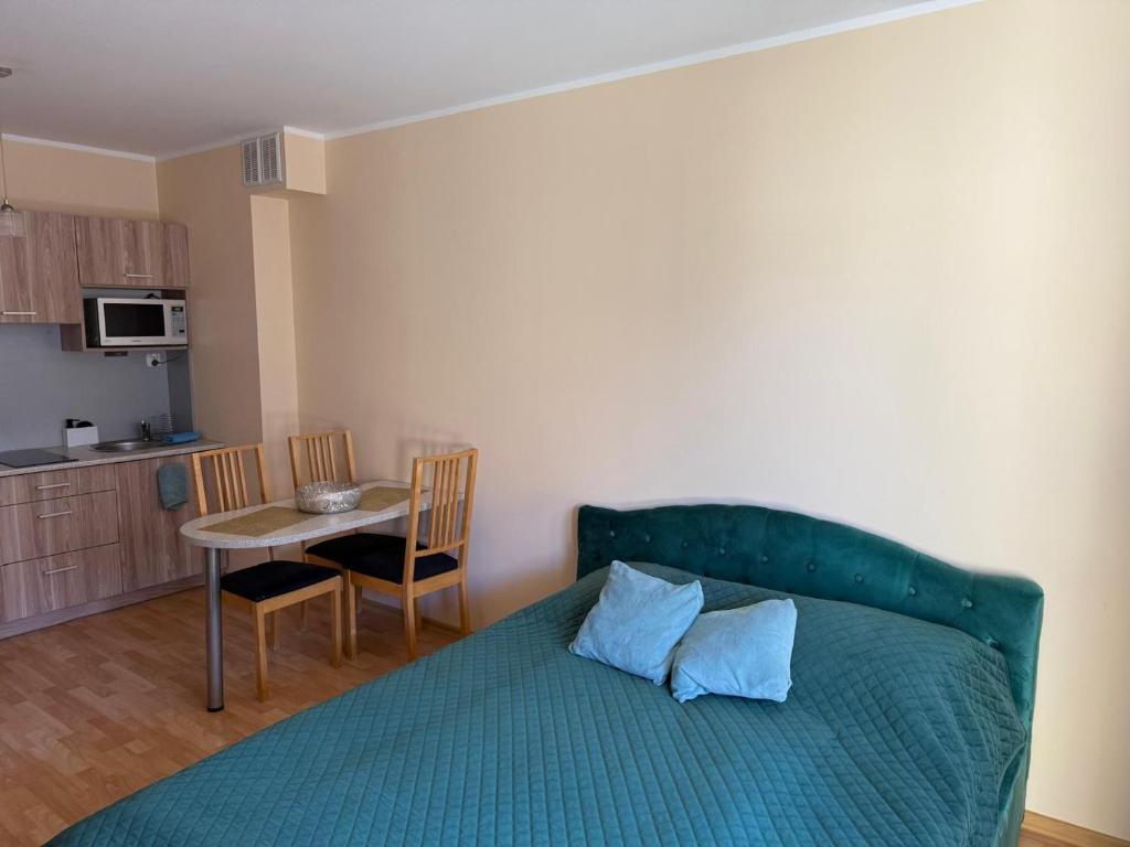a bedroom with a bed and a table and a kitchen at Apartament Muzungu in Świnoujście