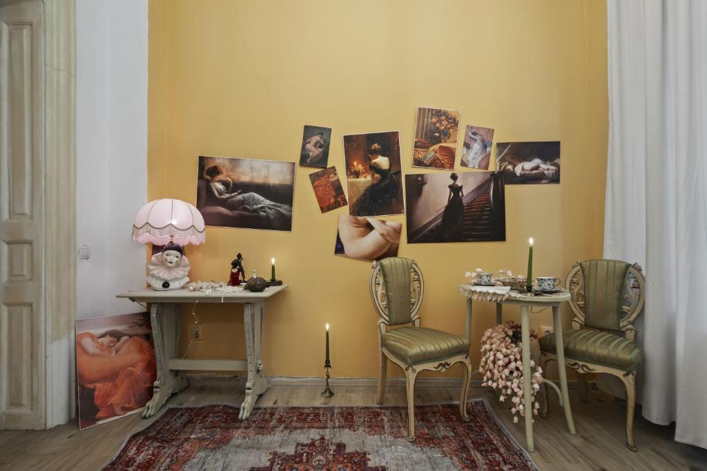 a room with two chairs and pictures on the wall at Creative retreat and Artist Haven Bohemian Villa on Calea Victoriei in Bucharest