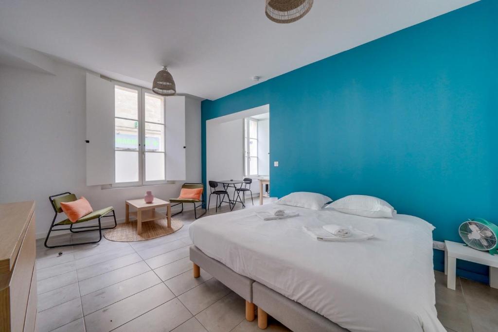 une chambre avec un grand lit avec un mur bleu dans l'établissement Beau studio confortable Bordeaux, à Bordeaux