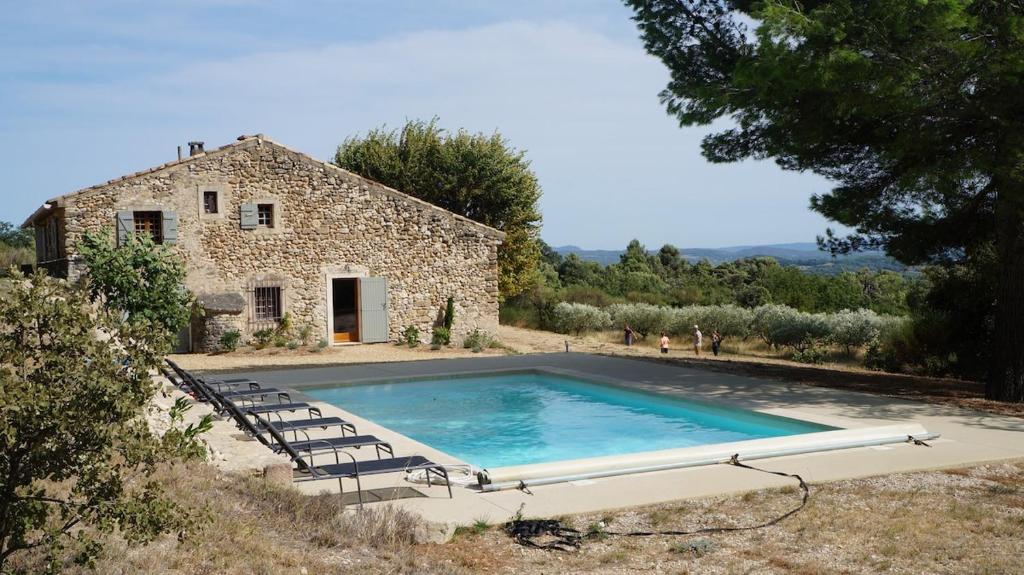 a large swimming pool in front of a stone house at Large Provençal Bastide - With Private Pool in Cucuron