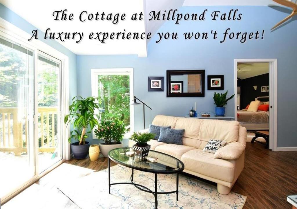 a living room with a couch and a glass table at Cottage at Millpond Falls - A Romantic Escape in Warwick