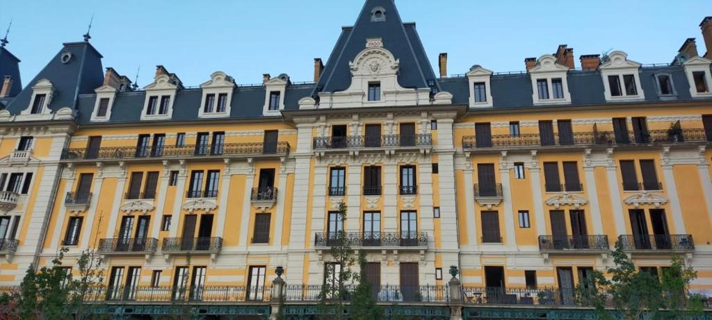 un grand bâtiment jaune avec un toit noir dans l'établissement Studio le 121 - Palace Le Bernascon, à Aix-les-Bains