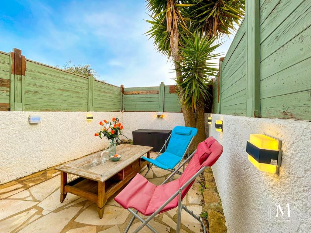 d'une terrasse avec une table en bois et 2 chaises. dans l'établissement Logement avec jardinet dans résidence avec piscine, à Sanary-sur-Mer