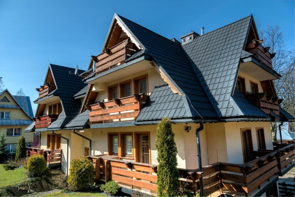 uma casa com telhado de metal em udanypobyt Apartamenty Skocznia em Zakopane