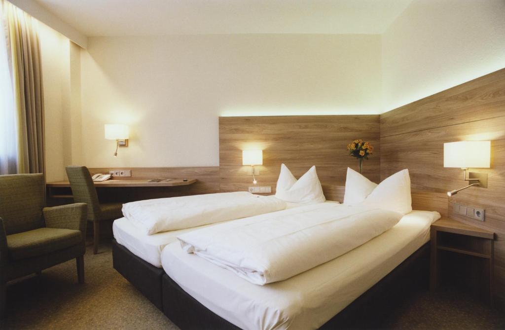 a hotel room with a large bed and a desk at Hotel Jedermann in Munich