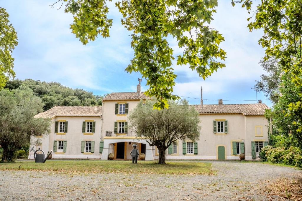 an exterior view of a large house with trees at La Bastide in Saint-Raphaël