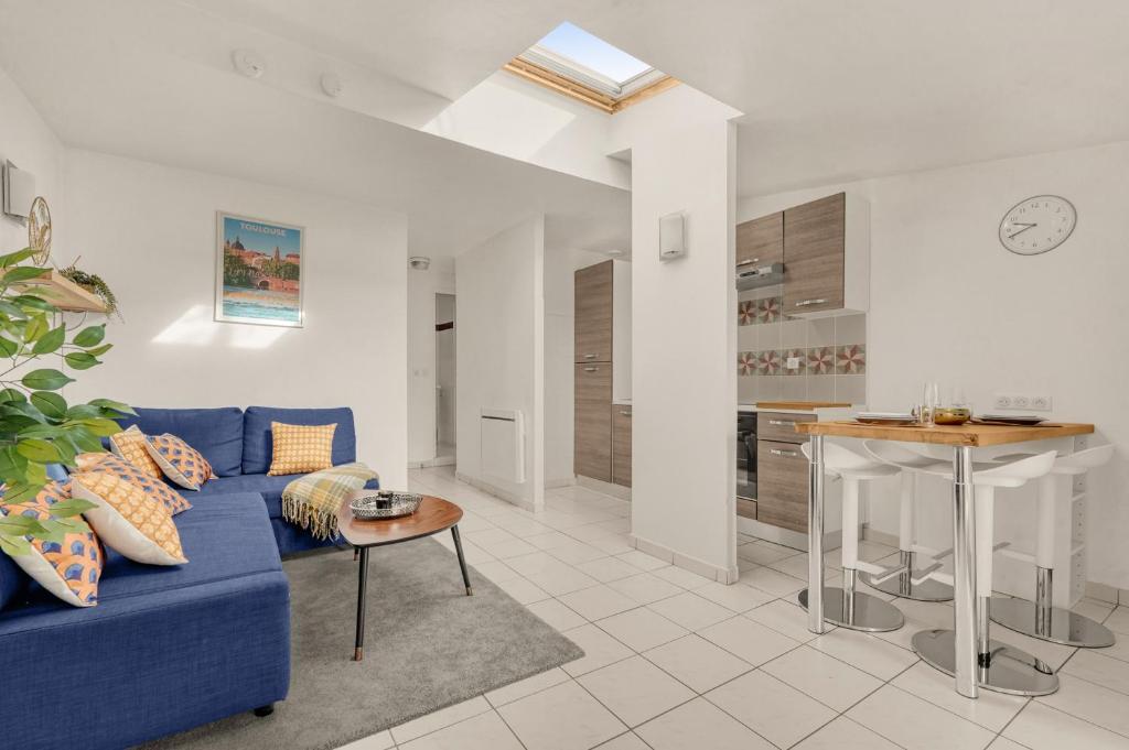 un salon avec un canapé bleu et une cuisine dans l'établissement Bourse des Marchands - 5min de Place du Capitole, à Toulouse