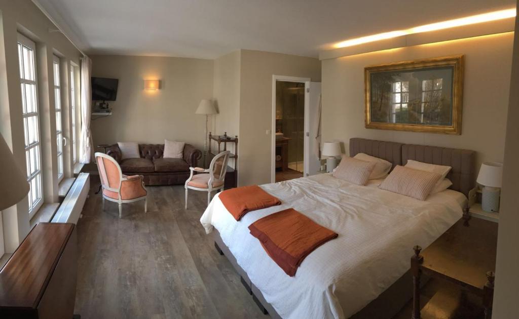 ein Schlafzimmer mit einem großen Bett und ein Wohnzimmer in der Unterkunft Bed and Breakfast Ros & Marc in Wezembeek-Oppem