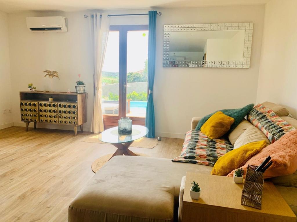 un salon avec un canapé et une table dans l'établissement Warm house with pool and HOT TUB, à Villeveyrac