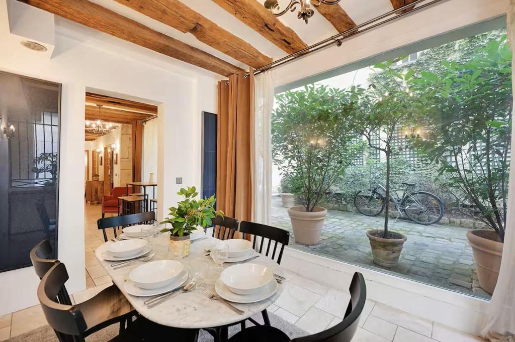 une salle à manger avec une table et une grande fenêtre dans l'établissement Appartement Maître Albert, à Paris