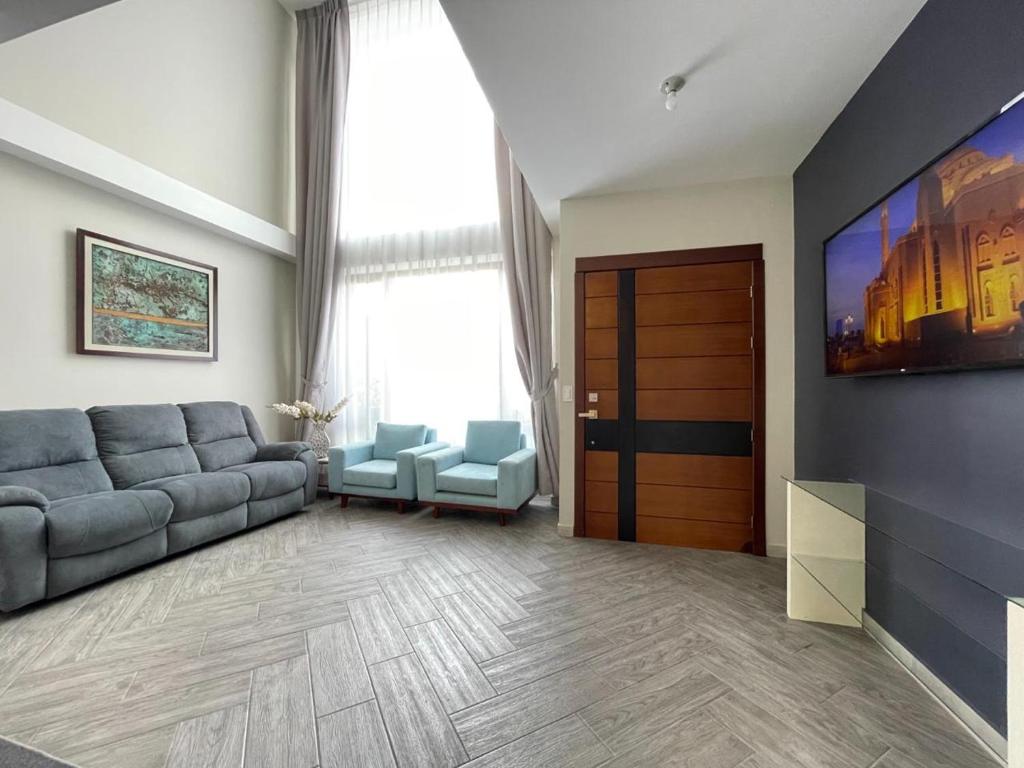 a living room with a couch and a tv at Luxury Villa with Jacuzzi 4 Bedroom 4 Bath in Baños