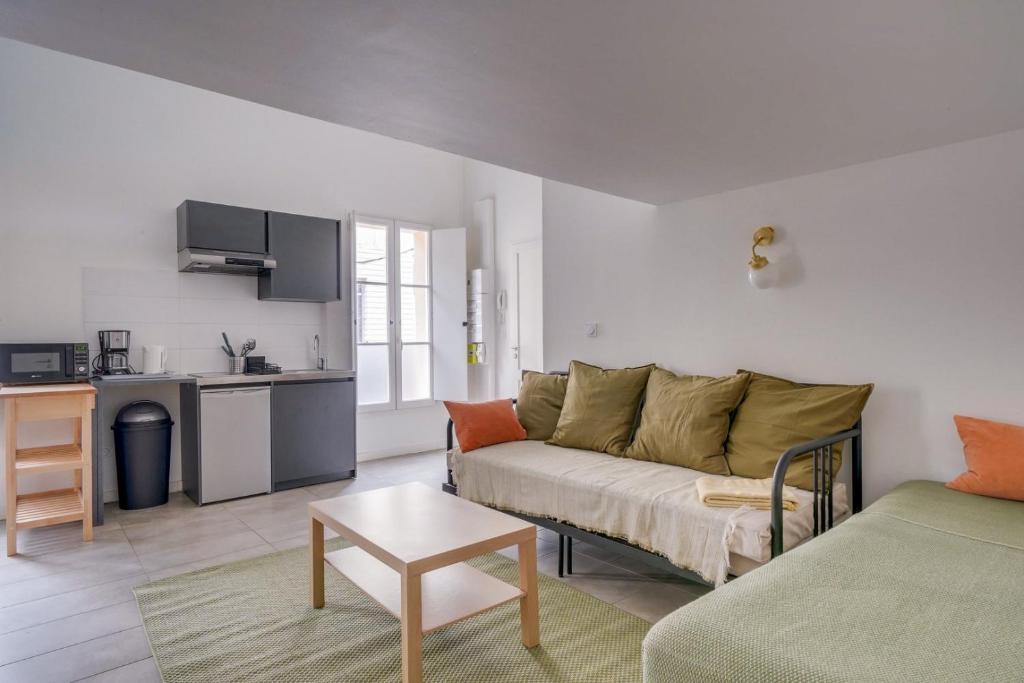 un salon avec un canapé et une cuisine dans l'établissement Bel appartement confortable Bordeaux, à Bordeaux