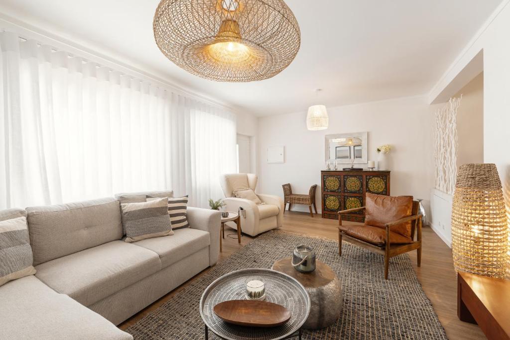 una sala de estar con un sofá y una mesa en SeaBreeze Residence, en Atouguia da Baleia