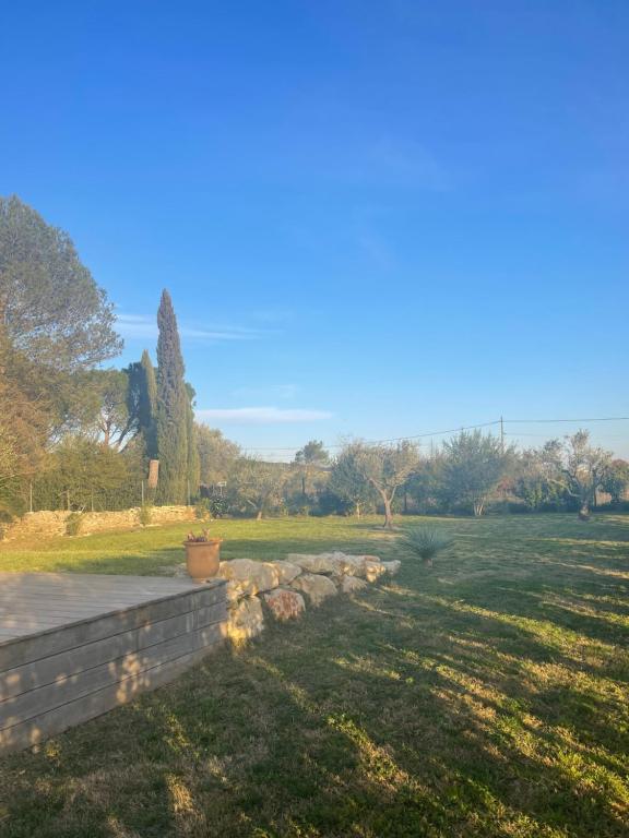 un jardin avec un mur en pierre et un champ dans l'établissement Maison entière Uzès 3 chambres, à Uzès